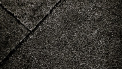 Black or dark gray rough grainy stone texture background with geometric line feature, copy space