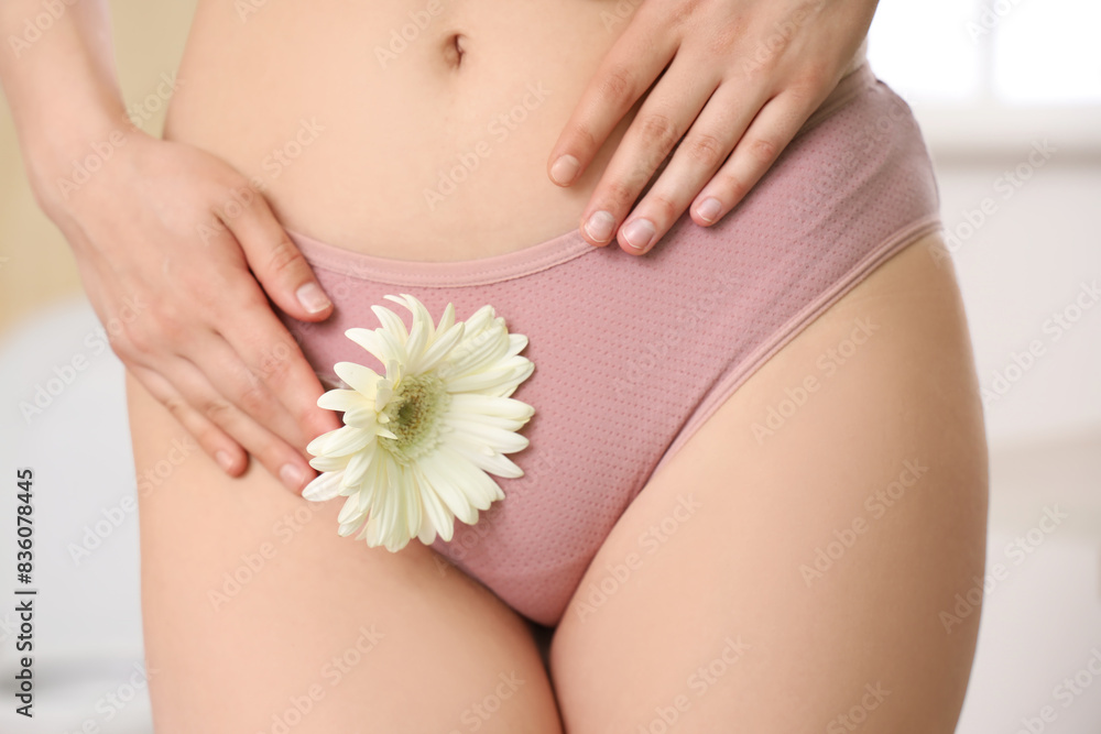 Sticker Young woman in menstrual panties with flower at home, closeup