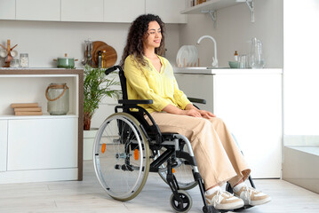 Young African-American woman in wheelchair at home