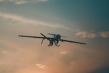 Fototapeta premium Reconnaissance drone is seen flying high in the sky against a backdrop of a colorful sunset