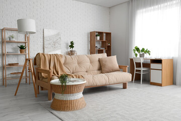 Interior of light living room with white sofa, houseplants and coffee table