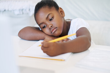 Black child, book and writing notes in home, homework and knowledge for education at table. Female...