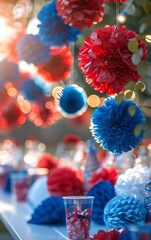 Naklejka premium Red, white, and blue pom-poms hang from a string, creating a festive backdrop for a party.