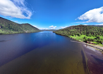 Fototapeta premium beautiful landscape with mountains and Lake Teletskoye against a background of blue sky from a drone in May