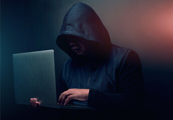 Online, hacker and man with laptop in studio for cyber attack, ransomware and scam on database....