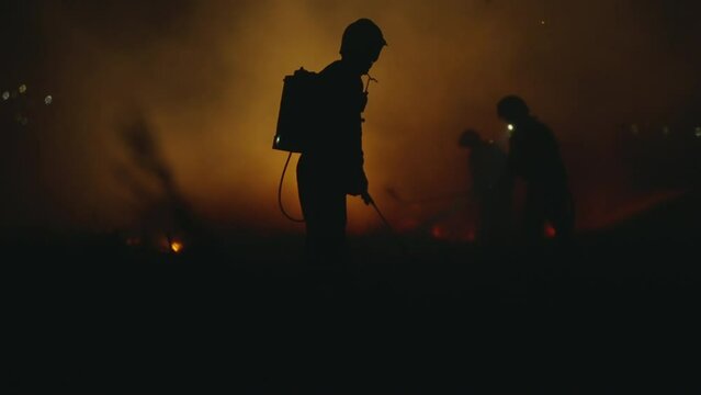 Slow motion Firefighters using Twirl water fog type fire extinguisher to fighting with the fire flame