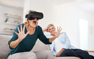 Obraz premium Couple, home and happy with vr for games on sofa for online video challenge and fun. Metaverse experience, futuristic and technology on couch for gaming, contest and competition or hobby as people