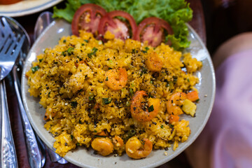Vietnamese food, fried rice, made from rice, eggs, sausage, dried shrimp, beans, cucumbers, tomatoes, carrots and green onions, high view plate on wooden background