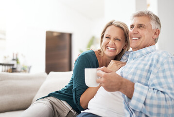 Relax, coffee and mature couple on sofa for love, connection or bonding together in living room....