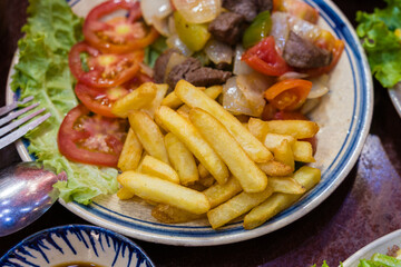 Stir frying beef with sweet peppers and bok choy and fried potato. Spicy beef with vegetables. Asian style food. Top view. Colorful stir-fry closeup
