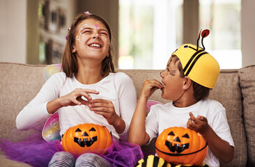 Halloween, eating candy and kids in home with costume for holiday event, celebration and happiness...