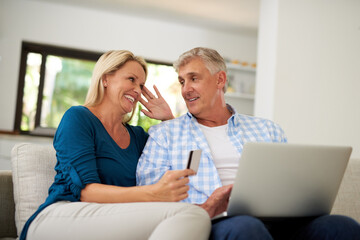 Couple, living room and laptop with credit card on sofa for online shopping, payment and saving...