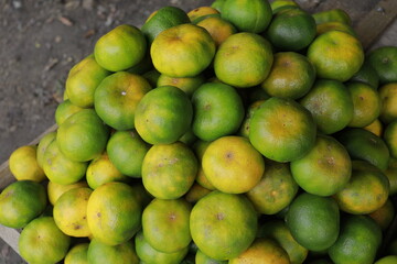 oranges, pile of green peel oranges on the market