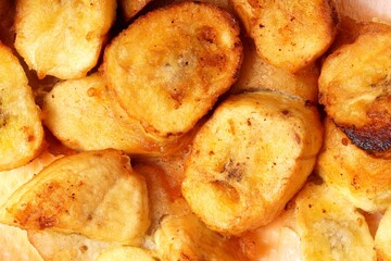 A close-up of crispy banana fritters, coated in golden batter and cut into bite-sized pieces. Perfect for capturing the delicious, mouthwatering appeal of this popular snack.