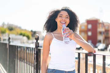 Young African American woman with a bottle of water at outdoors