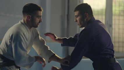Slow-moion shot of two young karate fighters having a fight in practice session. Close-up handheld shot - Powered by Adobe