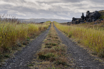 Fototapeta premium Endless gravel road leading up to clouds. The way forward concept