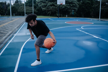 A single young man playing basketball