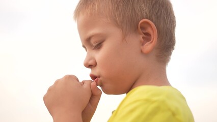 child boy praying. happy family a religion prayer faith concept. blond boy praying hands to face on...