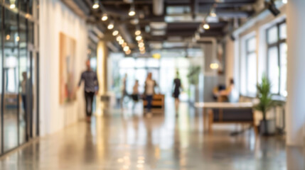 Blurred office background with people working. Blurred image of a modern office interior with people walking and working, perfect for website banners and backgrounds.