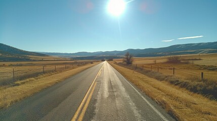 Naklejka premium Endless Summer Adventure: Sunshine Casting Long Shadows on a Deserted Road