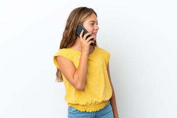 Little caucasian girl isolated on white background keeping a conversation with the mobile phone with someone