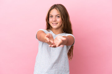 Little caucasian girl isolated on pink background holding copyspace imaginary on the palm to insert...