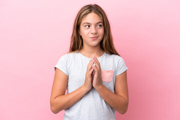 Little caucasian girl isolated on pink background scheming something