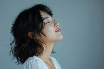 Fototapeta premium A close up of a woman's face with her eyes closed looking to a side