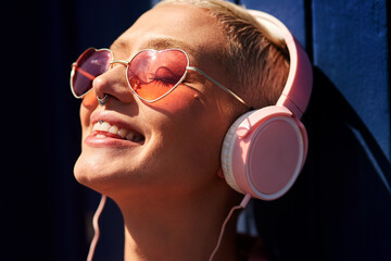Music, headphones and happy for podcast in the sun, radio with peace and heart glasses. Streaming,...