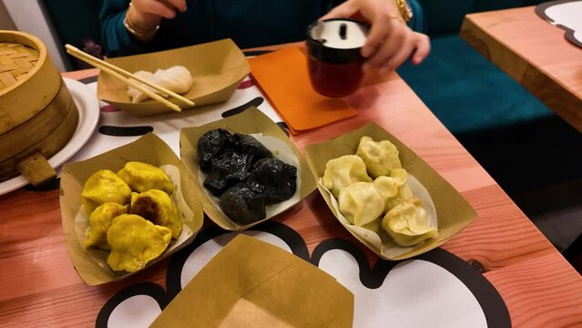 Woman's hands lift the lid of traditional Chinese dumplings. Shumai is a type of traditional Chinese dumpling. Cantonese cuisine food is usually served with dim sum. Stuffed with meat or fish veget