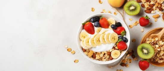 Nutritious breakfast featuring a bowl of Greek yogurt with oat granola, fruit, nuts, honey, and chia seeds, with a top view for a copy space image.