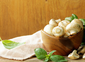 organic mushrooms champignons on a rustic wooden table