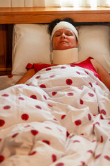 sick woman wearing a neck collar and a head bandage in the bed, accident victim
