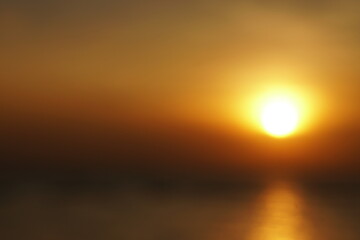 Blurred Tranquil scene of big red sun and yellow sky sunset over the sea at pattaya Thailand.