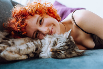 portrait red-haired teenage girl with gray fluffy cat