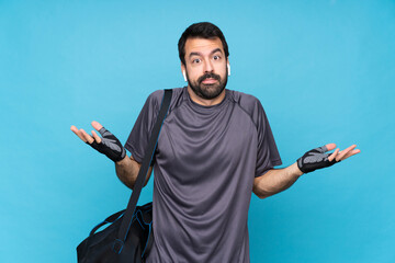 Young sport man with beard over isolated blue background making doubts gesture