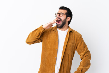 Caucasian handsome man with beard wearing a corduroy jacket over isolated white background yawning...