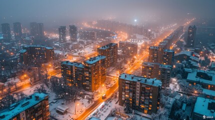 Fototapeta premium Aerial view of a snow-covered modern residential district at night with glowing street lights in Moscow.