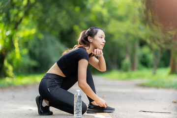 Healthy woman warms up before jogging and relaxes. Stretch your arms and look outside at the road,...