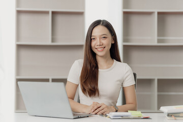 Businesswoman working on financial documents on the desk in the office is writing notes and calculating income and expenses.