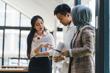 Three business professionals discussing charts in office.