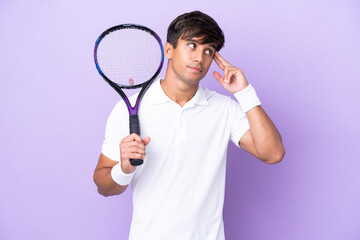 Handsome young tennis player man isolated on ocher background having doubts and thinking