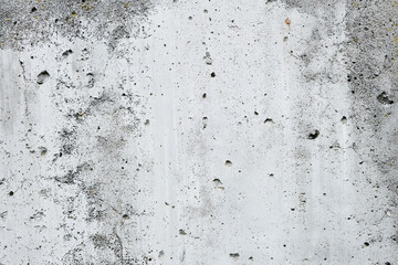 Cracked concrete wall covered with gray cement surface. Grey old wall with shabby damaged plaster or cement and brick background of an vintage dirty exfoliating plaster. Mock up.