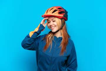 Young cyclist girl isolated on blue background smiling a lot