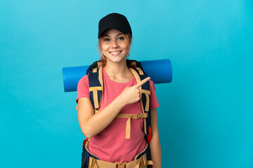 Teenager Russian hiker girl isolated on blue background pointing to the side to present a product