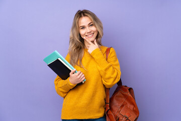 Teenager Russian student girl isolated on purple background smiling