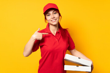 Pizza delivery girl holding a pizza over isolated background proud and self-satisfied