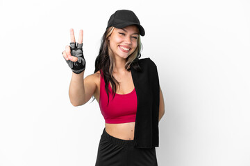 Sport Russian girl with hat and towel isolated on white background smiling and showing victory sign