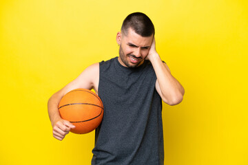 Young caucasian basketball player man isolated on yellow background frustrated and covering ears